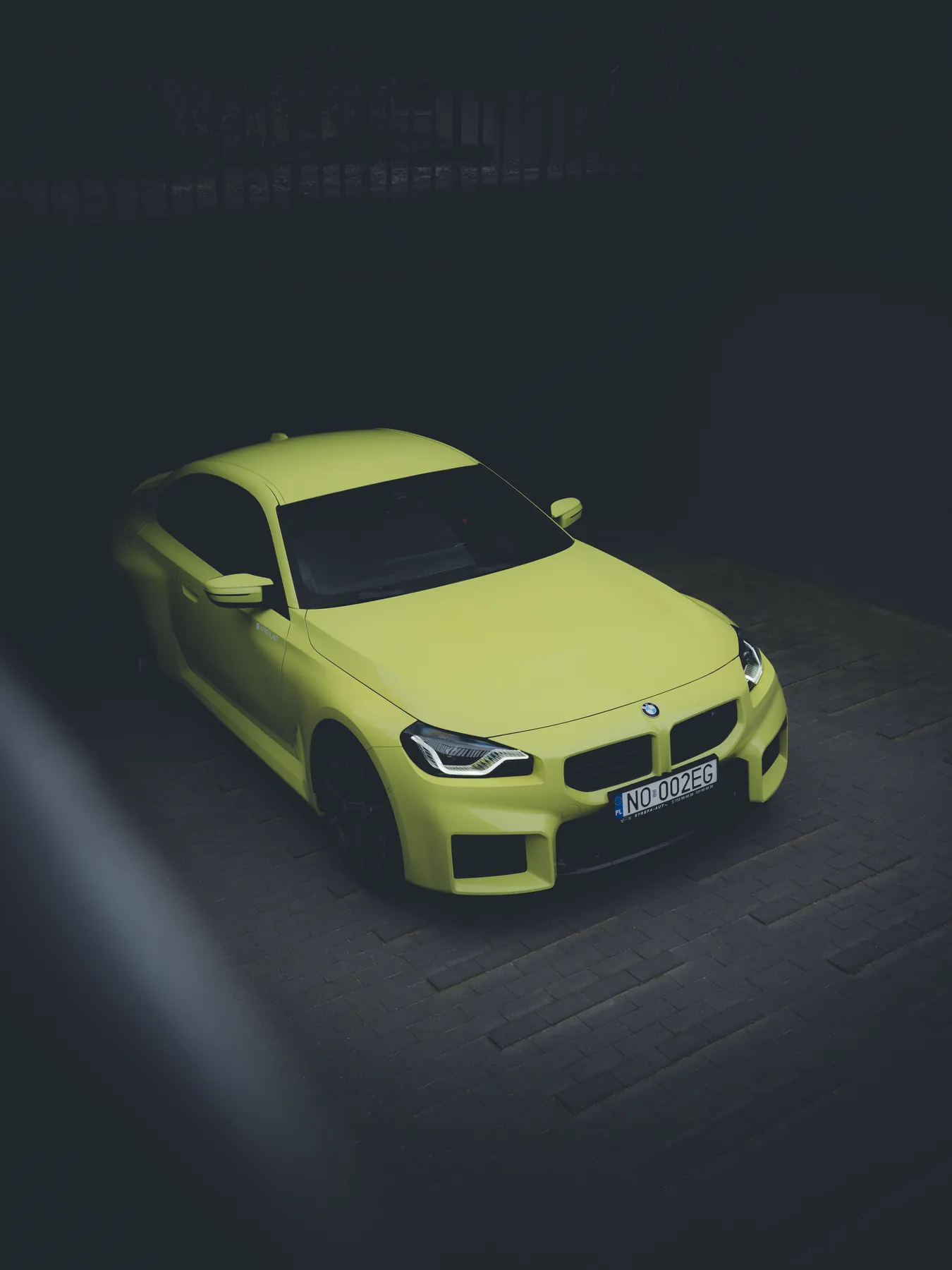 Limonkowe BMW M2 na ciemnym tle