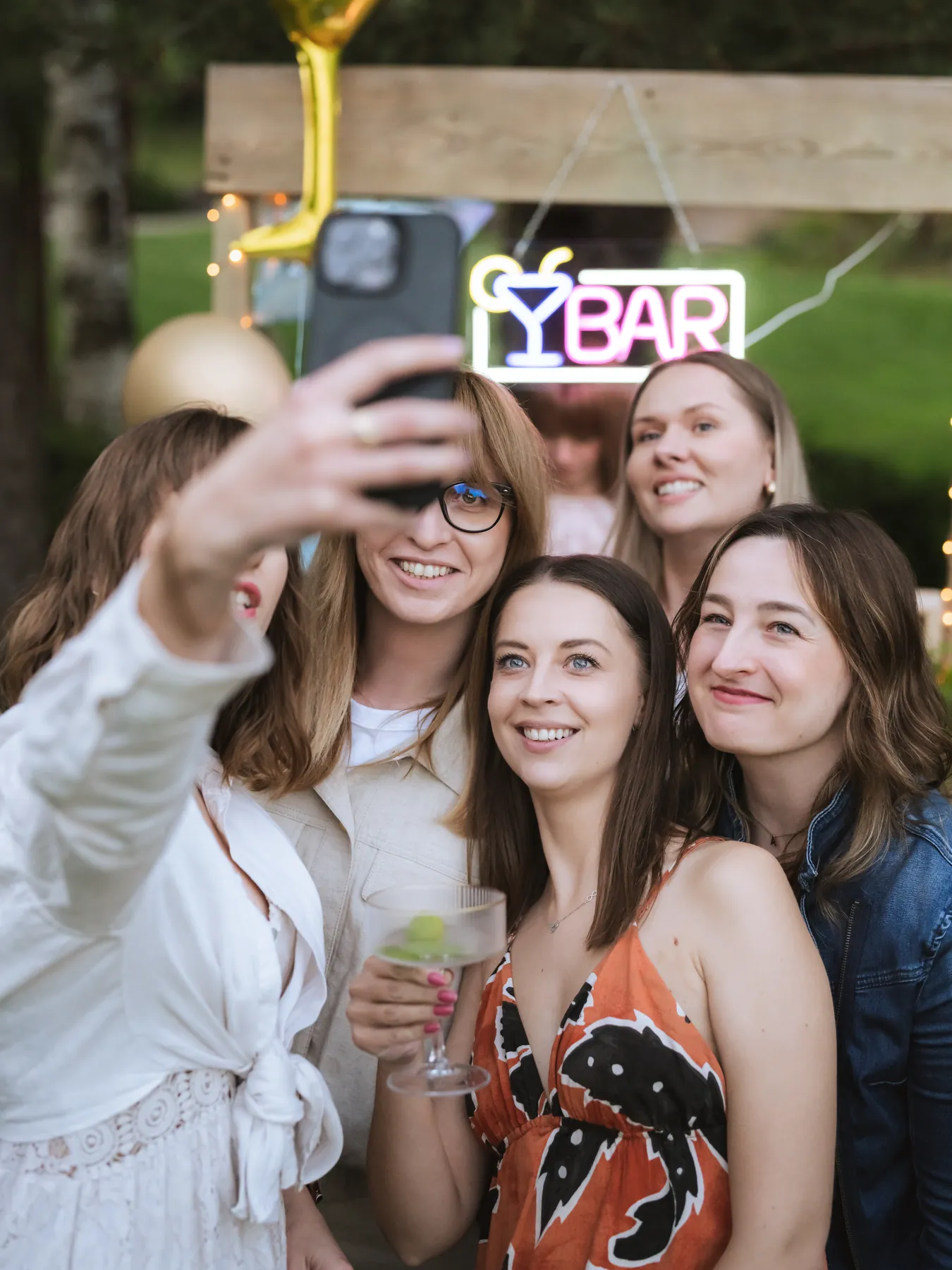 Przyjaciółki robią wspólne selfie przy barze w&nbsp;ogrodzie